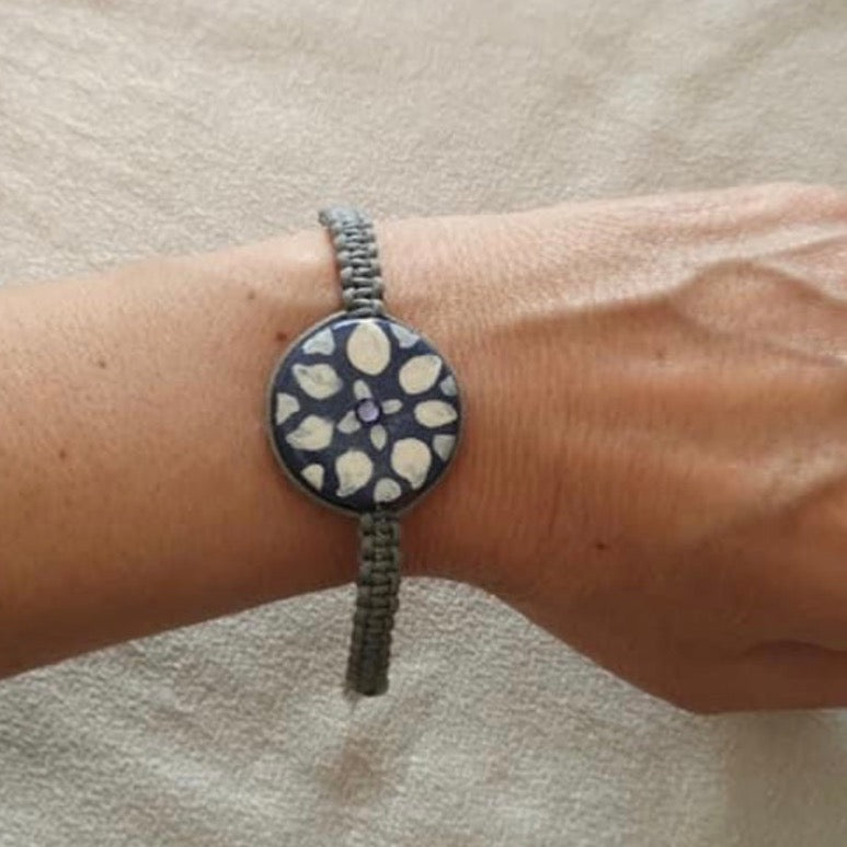 Bracciale grigio con fiore bianco su fondo ametista